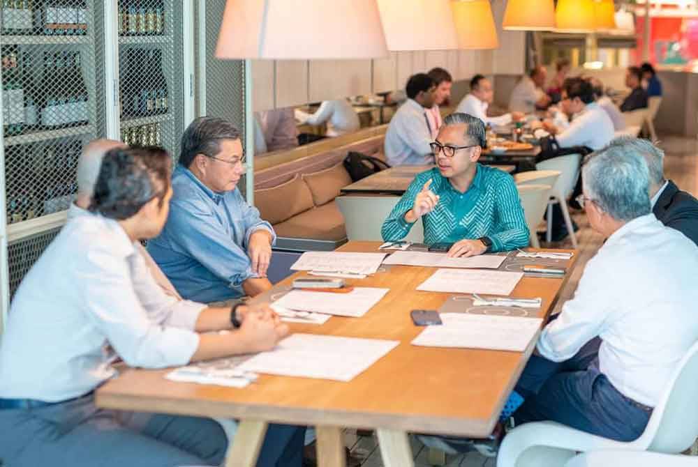 Fahmi (tengah) dalam proses perbincangan bersama syarikat-syarikat telco. Foto Facebook Fahmi Fadzil