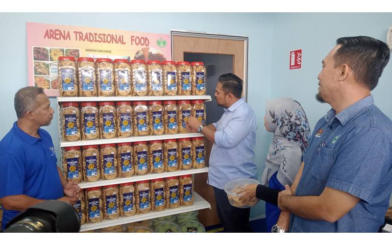 Manndzri (tiga dari kiri) meneliti produk rempeyek dan kuih ros yang dihasilkan Arena Traditional Food di premis Arena Traditional Food di Bandar Bestari Perdana, Pasir Gudang pada Ahad.