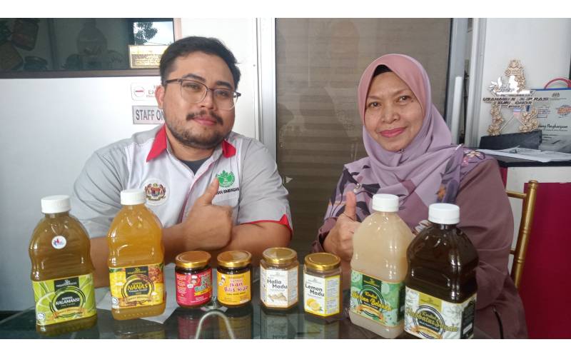 Norizan (kiri) dan anaknya, Bani Hakim menunjukkan produk-produk yang dihasilkan Nouriwellness di premisnya di Taman Desa Rakyat, Pasir Gudang pada Ahad.
