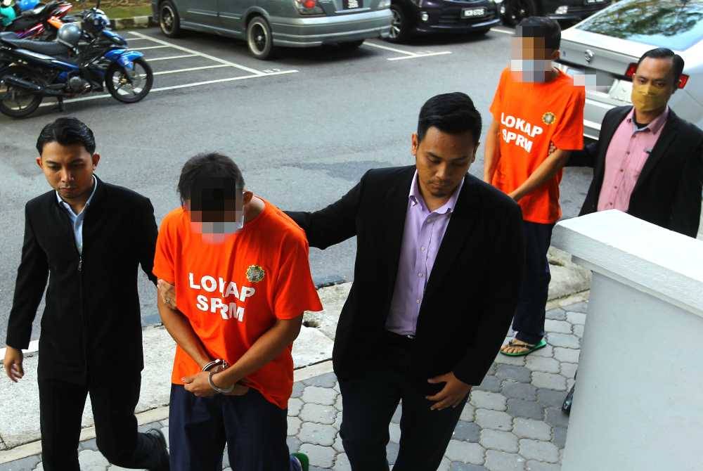 Kedua-dua suspek diiring pegawai SPRM di mahkamah.