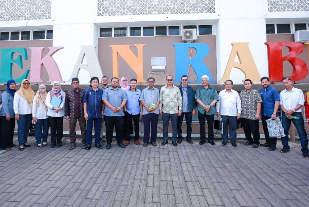 Mohd Salleh (lapan dari kanan) merakamkan kenangan di hadapan lanskap ikonik Pekan Rabu yang kini lebih ceria.