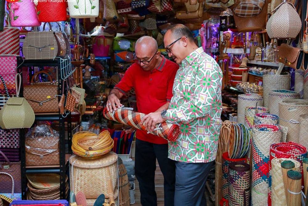 Mohd Salleh (kanan) mengadakan kunjungan mesra melawat premis perniagaan di kompleks Pekan Rabu.