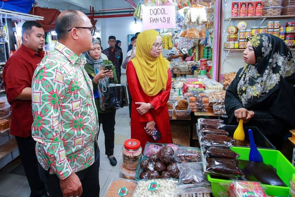 Mohd Salleh (kiri) meninjau premis menjual makanan tradisional popular, dodol ketika mengadakan lawatan kerja ke Pekan Rabu.