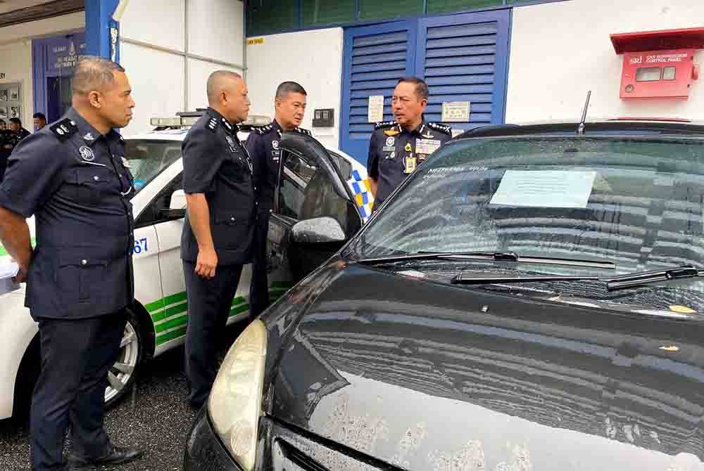 Muhamad Zaki (kanan) menunjukkan kereta yang dinaiki suspek yang berjaya ditemukan di Taman Desa Rahmat, Kubang Kerian.
