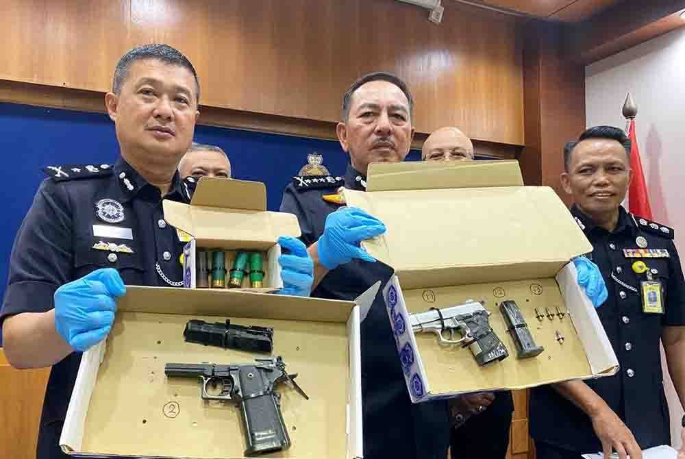 Muhamad Zaki (tengah) bersama pegawai terlibat menunjukkan pistol yang dirampas semasa sidang akhbar pada Rabu.