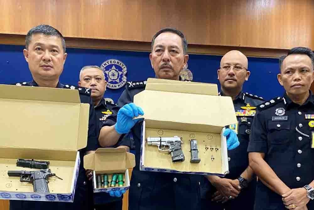 Muhamad Zaki (tengah) bersama pegawai terlibat menunjukkan pistol yang dirampas semasa sidang akhbar pada Rabu.