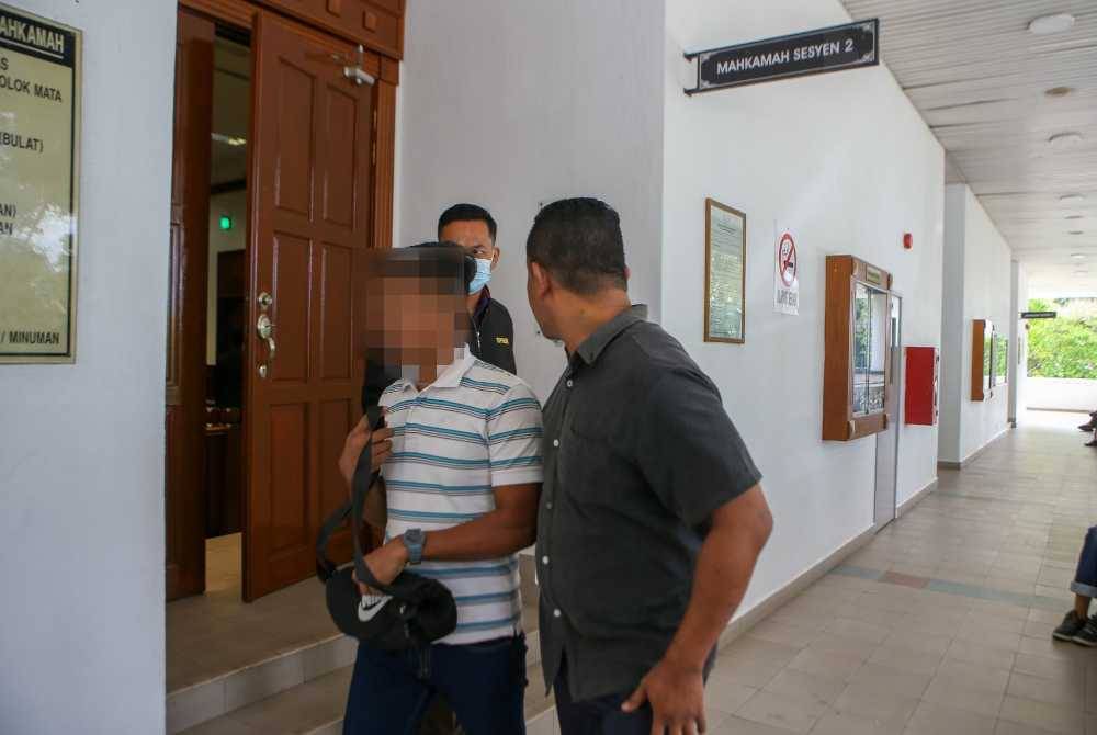 Tibrani (kanan) bersama penjaminnya diiringi anggota SPRM untuk membayar jumlah wang jaminan di Mahkamah Alor Setar pada Rabu.