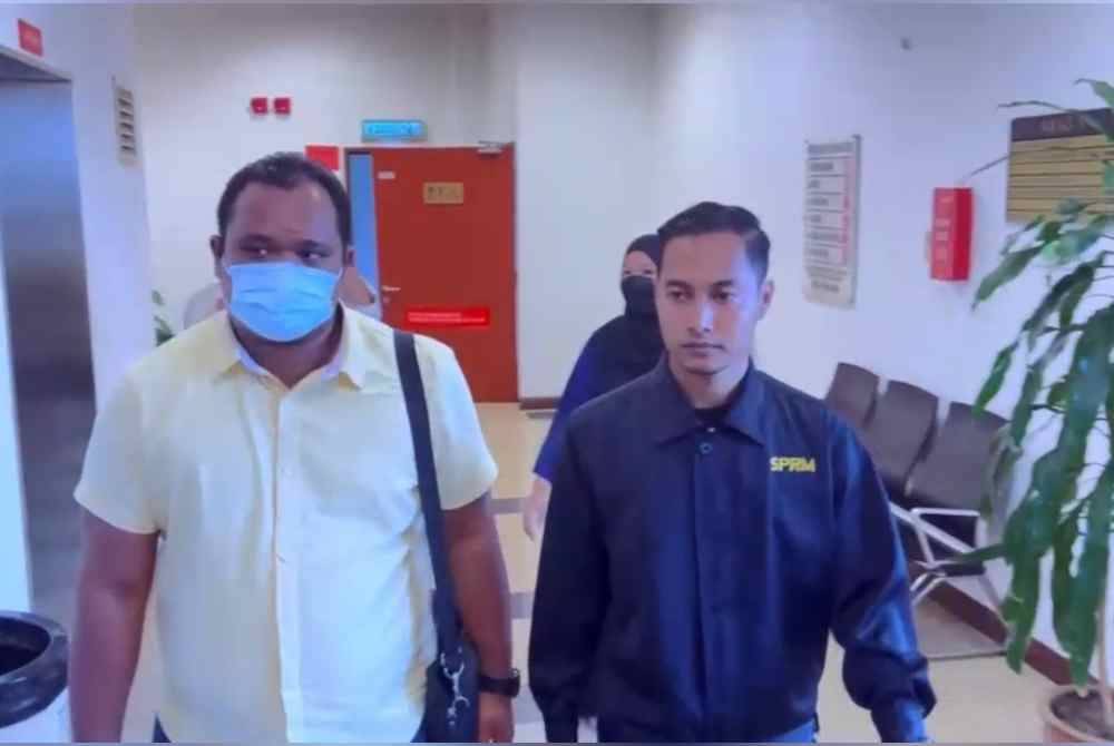 Ahmad Alfiz (kiri) hadir di Mahkamah Sesyen Shah Alam pada Rabu, bagi menghadapi 20 pertuduhan membuat tuntutan palsu.