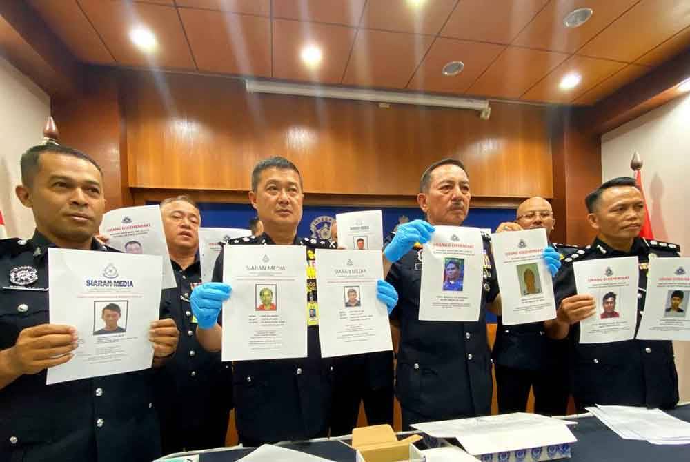 Muhamad Zaki (dua dari kanan) menunjukkan individu yang dikehendaki bagi membantu siasatan.