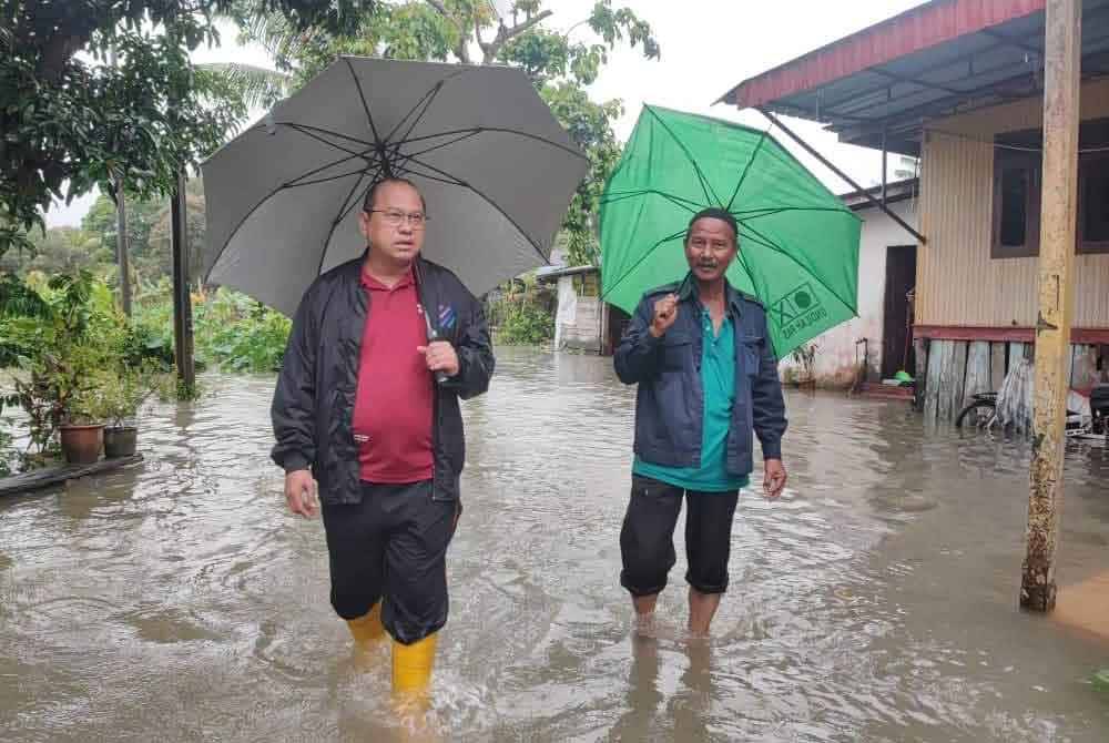 Ahmad Amzad (kiri) ketika melawat sekitar kawasan yang dinaiki air pada Selasa. Foto Facebook Ahmad Amzad Hashim