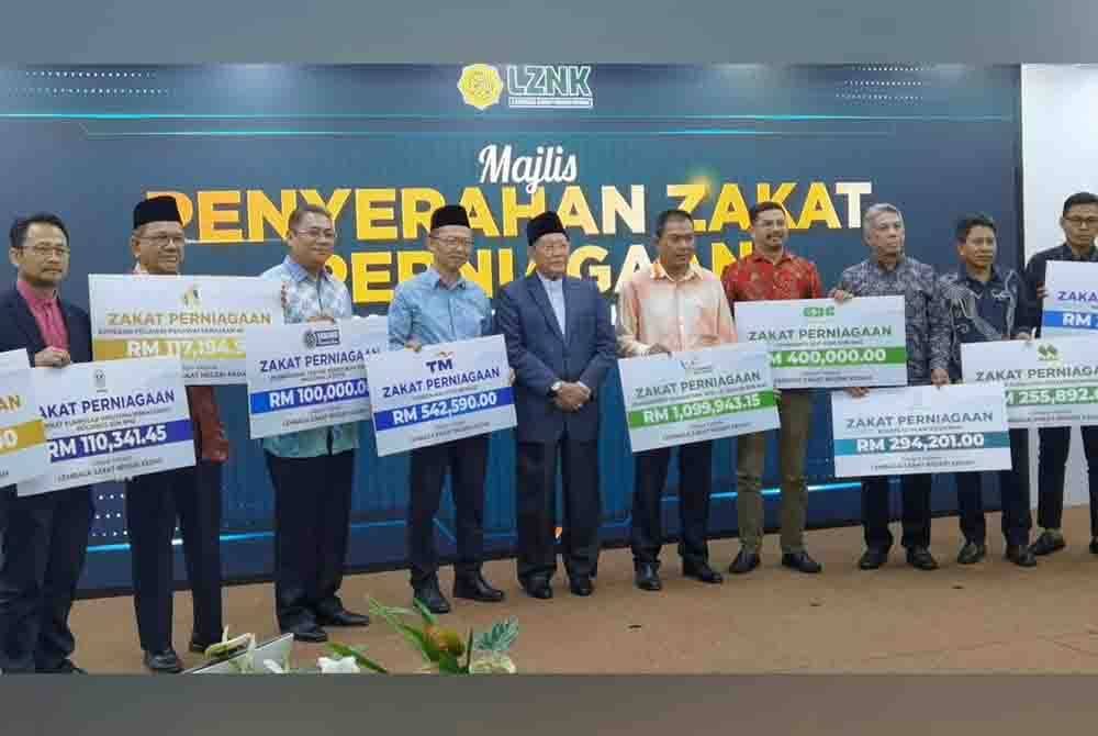 Mufti Kedah, Datuk Syeikh Fadzil Awang (tengah) menerima replika cek zakat perniagaan berjumlah RM3.79 juta dari 14 syarikat korporat di Menara Zakat, Alor Setar pada Rabu.