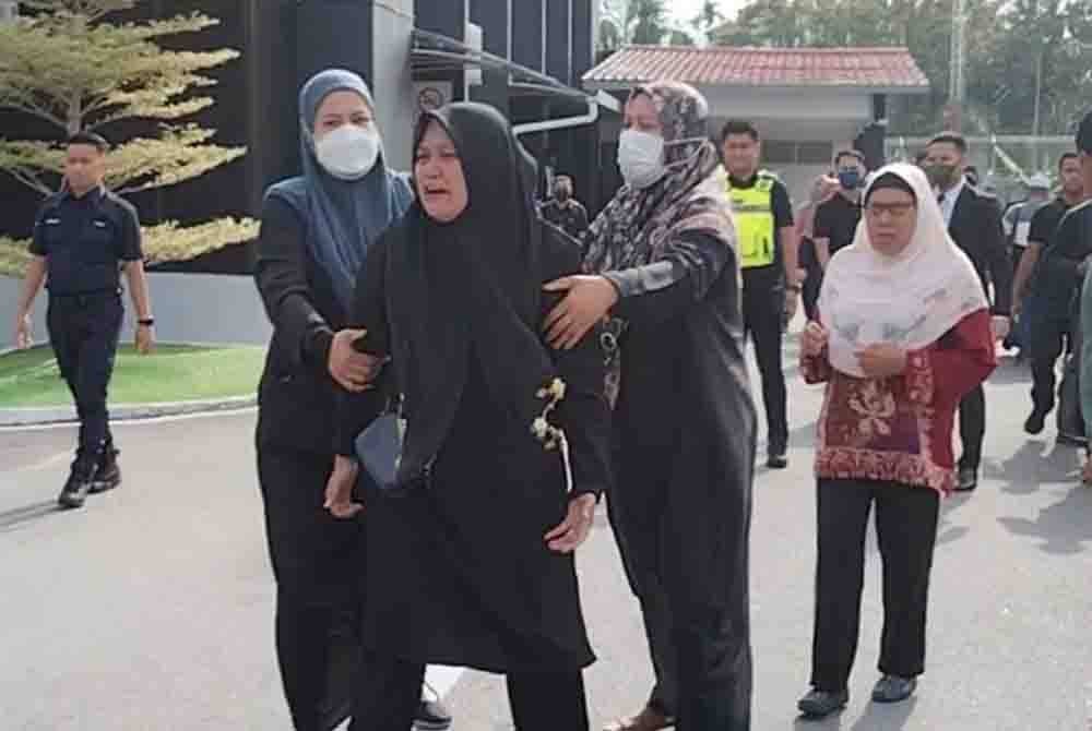 Norhisham ditenangkan oleh ahli keluarganya ketika menjerit di pekarangan Mahkamah Majistret Batu Pahat pada Rabu.