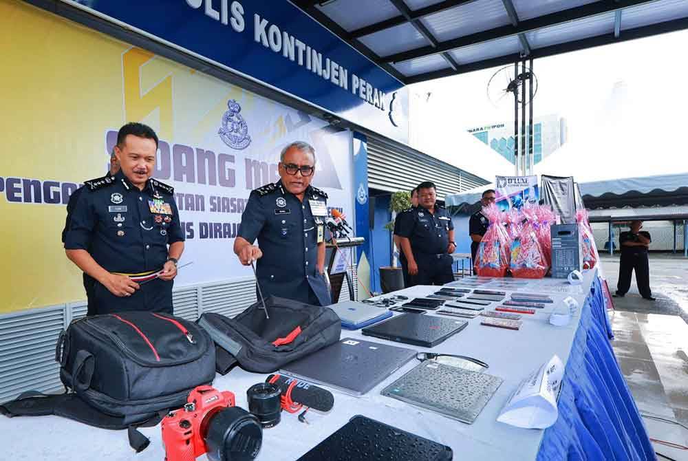 Ramli (dua dari kiri) menunjukkan rampasan yang dilakukan hasil penahanan 11 individu sebuah sindiket pelaburan mata wang kripto tidak wujud di sebuah hotel di Ipoh.