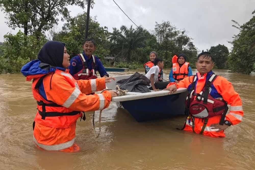 Pasukan penyelamat meredah banjir bagi memindahkan mangsa banjir ke tempat selamat. FOTO: APM