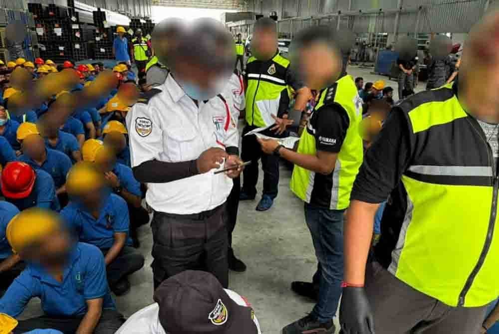 Pegawai imigresen memeriksa warga asing dalam Ops Mahir di sebuah kilang di Senai pada Rabu.