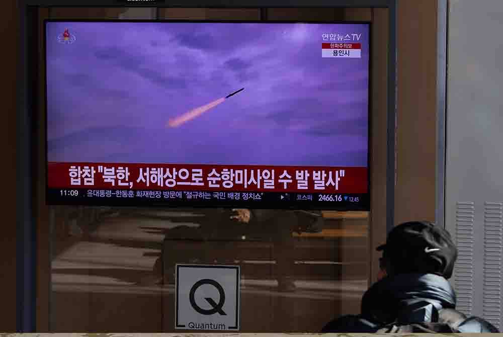 Seorang lelaki menonton skrin televisyen yang menyiarkan berita peluru berpandu yang dilancarkan oleh Korea Utara. Foto EPA