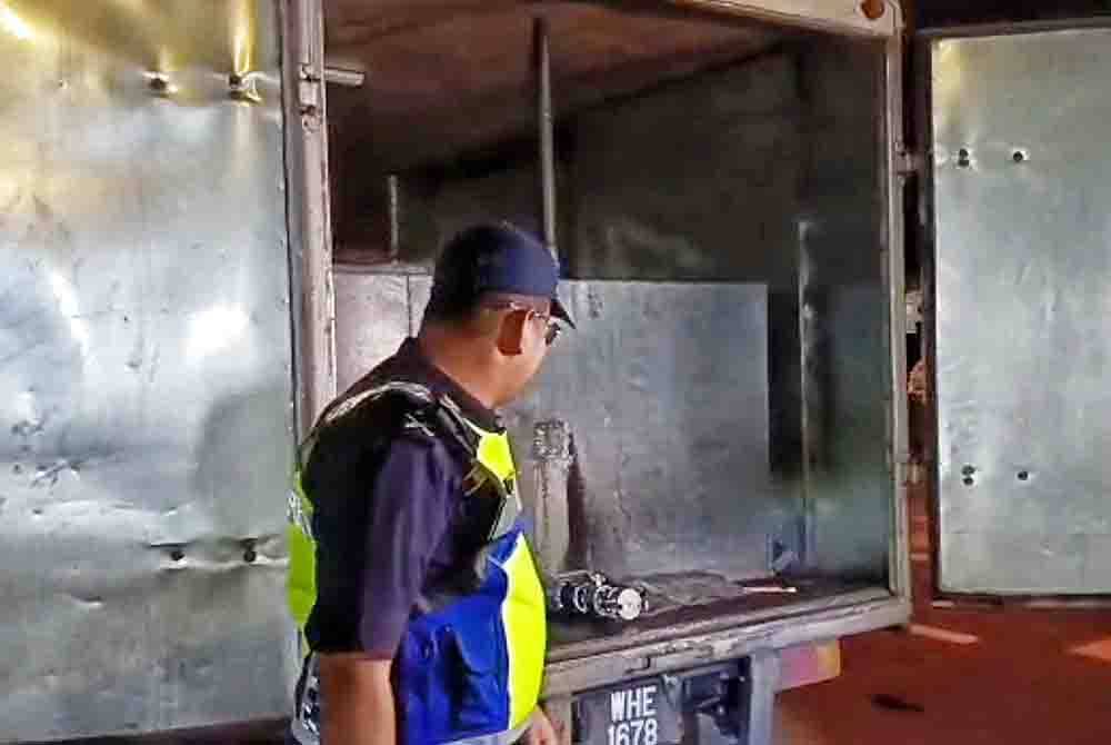 Mohd Firdaus melihat sebuah lori yang ditahan dalam operasi bersepadu di Lebuh AMJ di Paya Rumput pada malam Rabu.