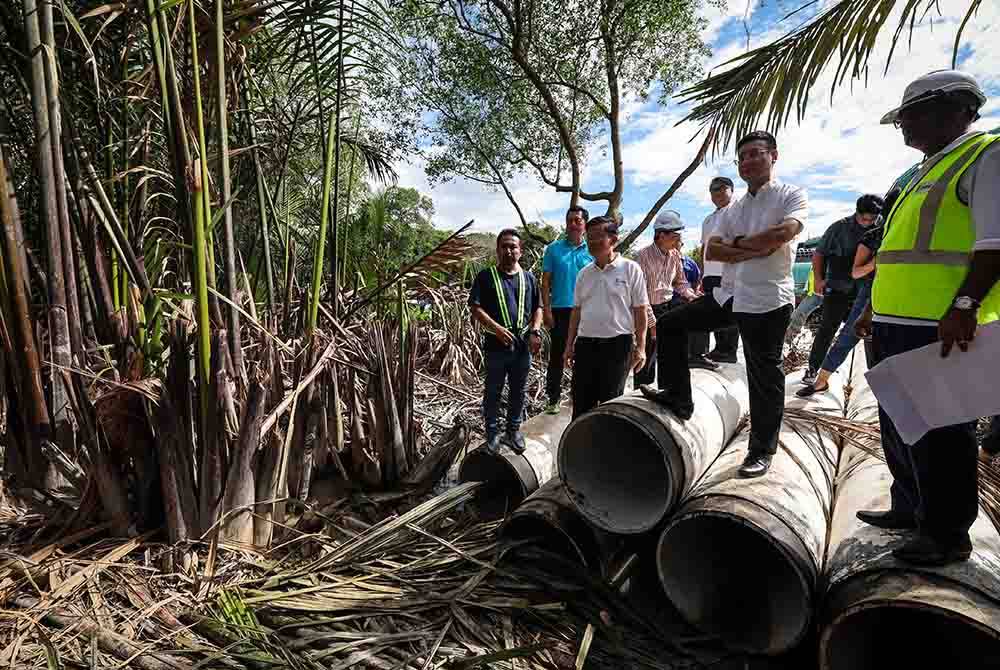 Kon Yeow (tiga, kiri) meninjau kerja-kerja melibatkan penyambungan dua saluran paip 600 mm dan pemotongan sambungan 1,350 mm paip di bawah air yang dilaksanakan di Sungai Perai pada Khamis. Foto Bernama