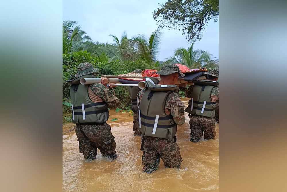 
Pasukan ATM mengharung banjir sedalam lebih satu meter bagi membawa jenazah Kalthom Mat, 84, yang meninggal dunia di rumahnya akibat sakit tua.