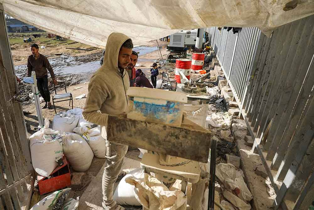 Orang ramai kisar bijirin menjadi tepung untuk dibuat roti di Kota Gaza pada Isnin di tengah-tengah pertempuran berterusan antara Israel dan pejuang Hamas. Foto AFP