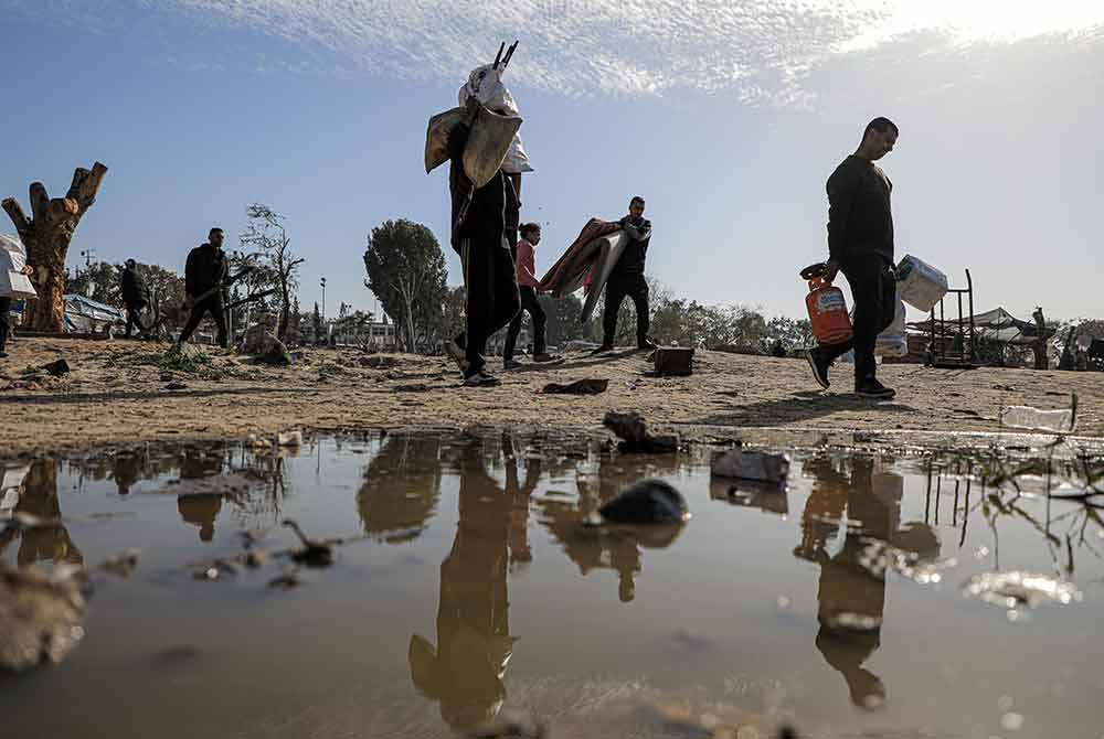 Orang ramai meninggalkan rumah mereka selepas pengeboman Israel di bandar Khan Younis, selatan Genting Gaza. Foto Bernama