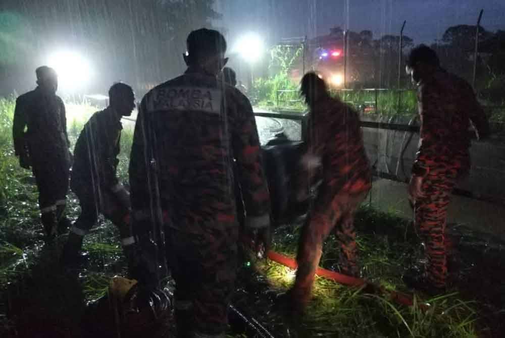 Anggota bomba pam air kolam bagi mengesan salah seorang mangsa yang disyaki hilang.