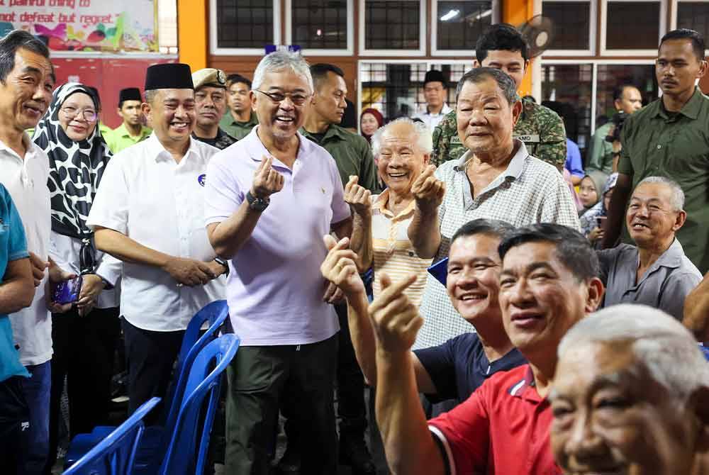 Yang di-Pertuan Agong Al-Sultan Abdullah Ri'ayatuddin Al-Mustafa Billah Shah berkenan bergambar bersama mangsa banjir ketika mencemar duli melawat PPS SMK Sungai Lembing pada Sabtu. - Foto Bernama