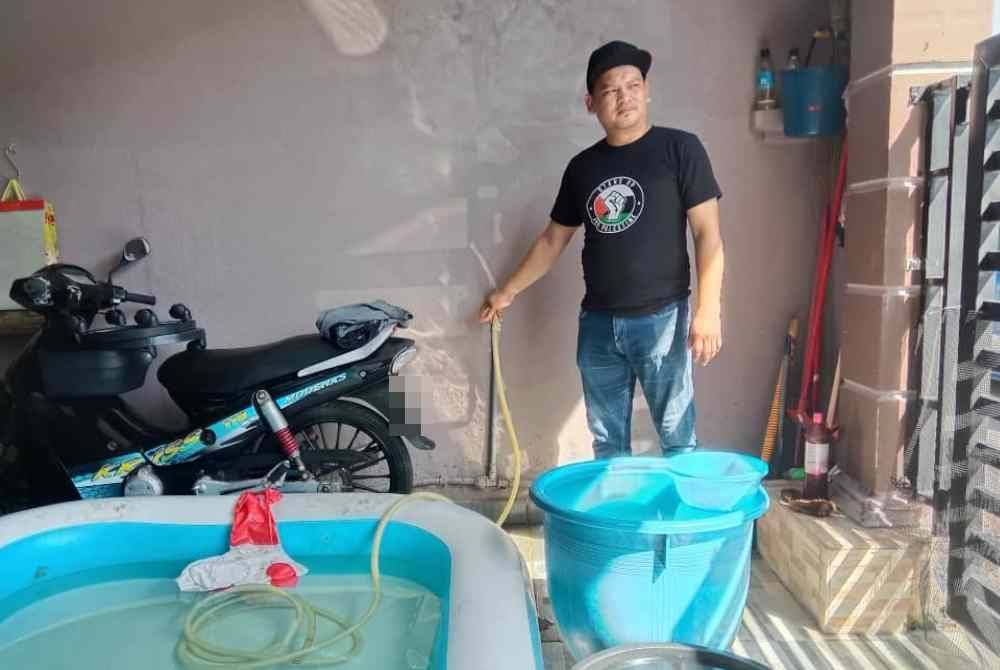 Mohd Sopian menunjukkan bekas air yang digunakan untuk mengisi stok air.