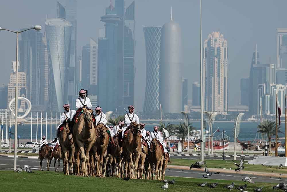 Sekumpulan pengawal istana menunggang unta masing-masing dengan berlatar belakangkan pencakar langit bandar Doha di hadapan laman Istana yang juga pusat pemerintahan Kerajaan Qatar, Amiri Diwan. Foto Bernama