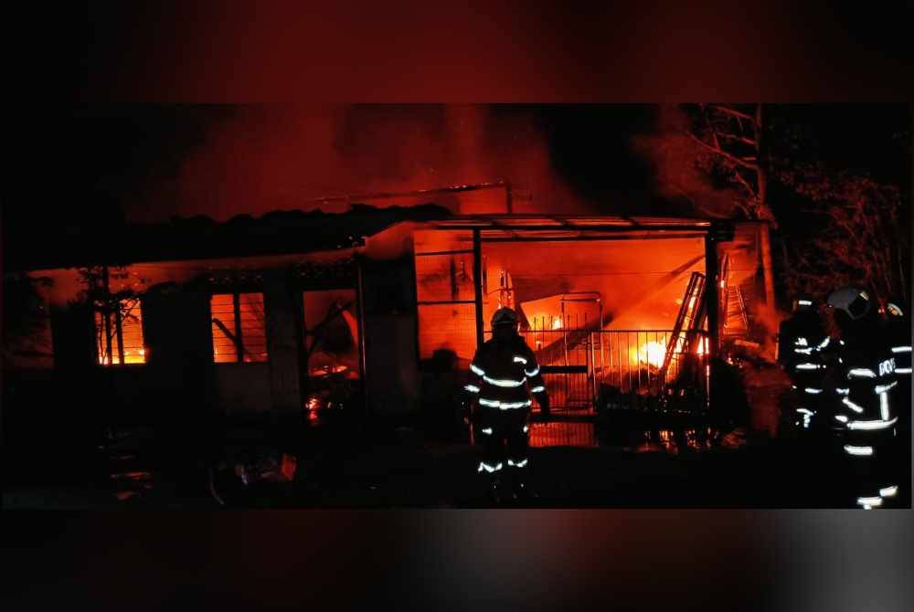 Anggota bomba giat memadamkan kebakaran.