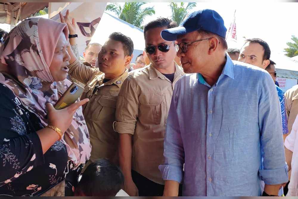 Anwar sempat beramah mesra dengan pengunjung, Fairos pada Jualan Termurah Madani barangan basah dan kering di Padang Taman Klebang Restu, Chemor.
