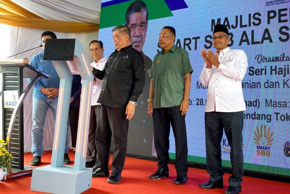 Mohamad (depan) merasmikan Majlis Perasmian SMART SBB Ala Sekinchan KADA di bendang Tok Ajam, Pasir Puteh.