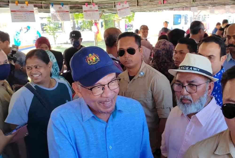 Syed Abu Hussin Hafiz (dua dari kanan) mengiringi Anwar pada program Jualan Termurah Madani barangan basah dan kering di Padang Taman Klebang Restu, Chemor pada Ahad.