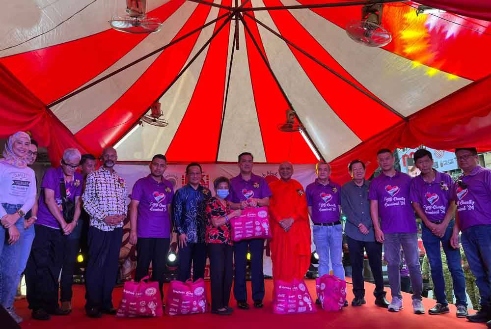 KK Chai (tujuh dari kanan) menyampaikan sumbangan kepada salah seorang penerima.