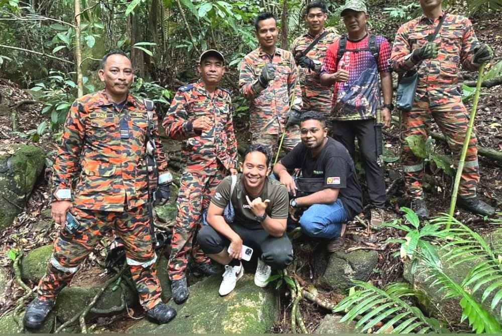 Anggota bomba merakam gambar bersama mangsa sebaik mereka berjaya diselamatkan pada petang Sabtu. Foto Bomba