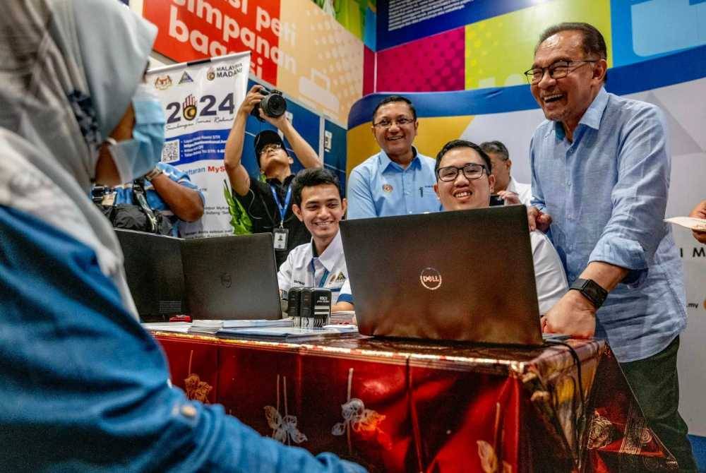 Anwar meninjau kaunter bergerak Lembaga Hasil Dalam Negeri Perak. Foto Facebook Anwar Ibrahim