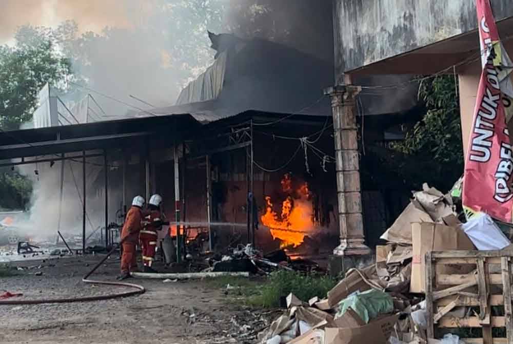 Anggota bomba berusaha memadam kebakaran melibatkan lima unit kedai alat ganti motosikal.