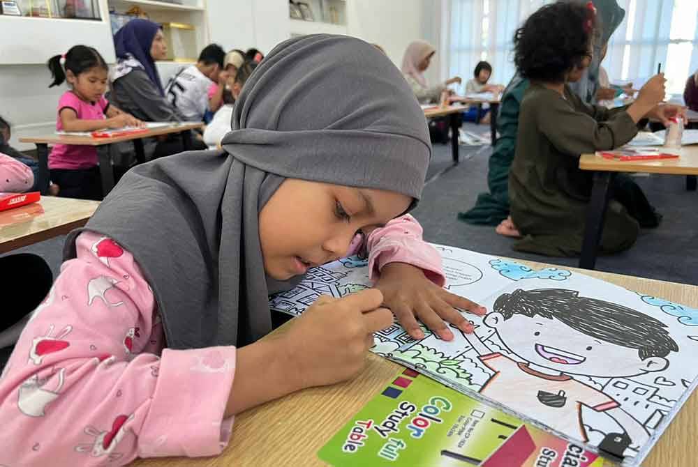 Nur Syamimie Yusra Abdullah, 8, menyertai pertandingan mewarna sempena Jualan Gudang Karangkraf 2024 di Kompleks Kumpulan Karangkraf, Shah Alam pada Ahad.