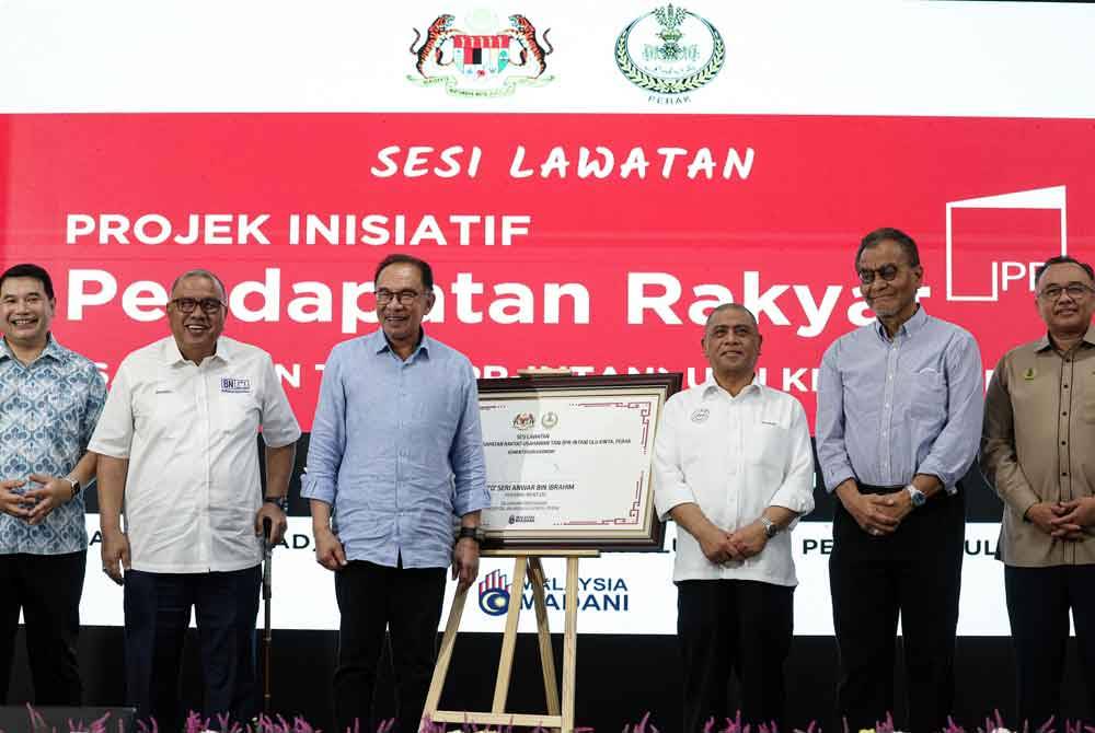 Anwar selepas menandatangani plak Inisiatif Usahawan Tani Wilayah Ekonomi Koridor Utara (IPR-Intan NCER) selepas melawat tapak projek IPR- Intan NCER di Hospital Bahagia Hulu Kinta hari ini. Foto Bernama