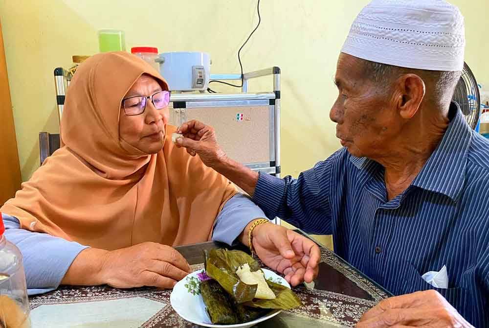 Abdullah menyuapkan kuih kepada Siti Zabidah.