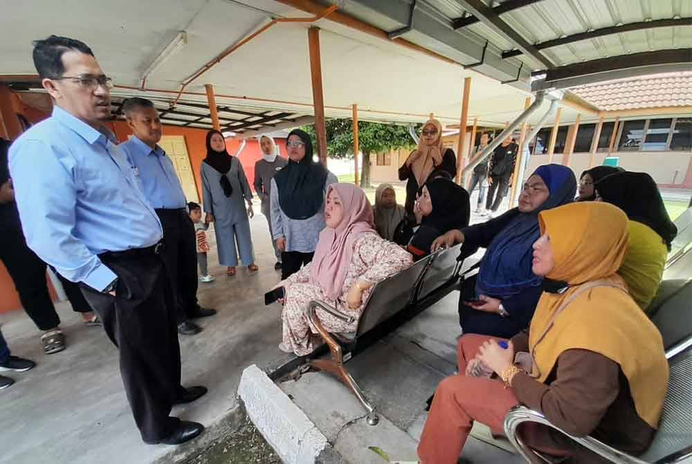 Norzihan (duduk kiri) semasa menunggu urusan bedah siasat anaknya yang terkorban dalam kemalangan di Unit Forensik HKT, Kota Tinggi pada Isnin.