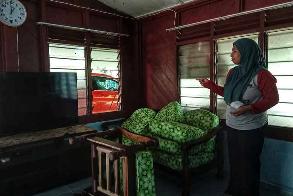 Ayu Nursuria menunjukkan tingkap rumahnya yang dipotong oleh penjenayah.