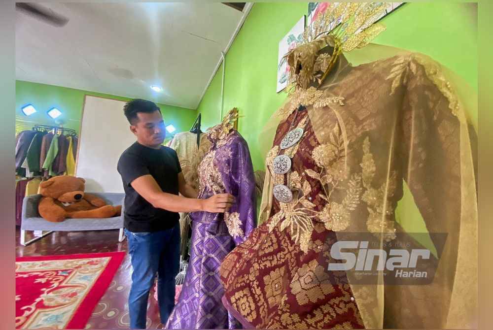 Mohd Riduwan sedang membetulkan busana pengantin pada patung di butik miliknya di Felda Bukit Kuantan.