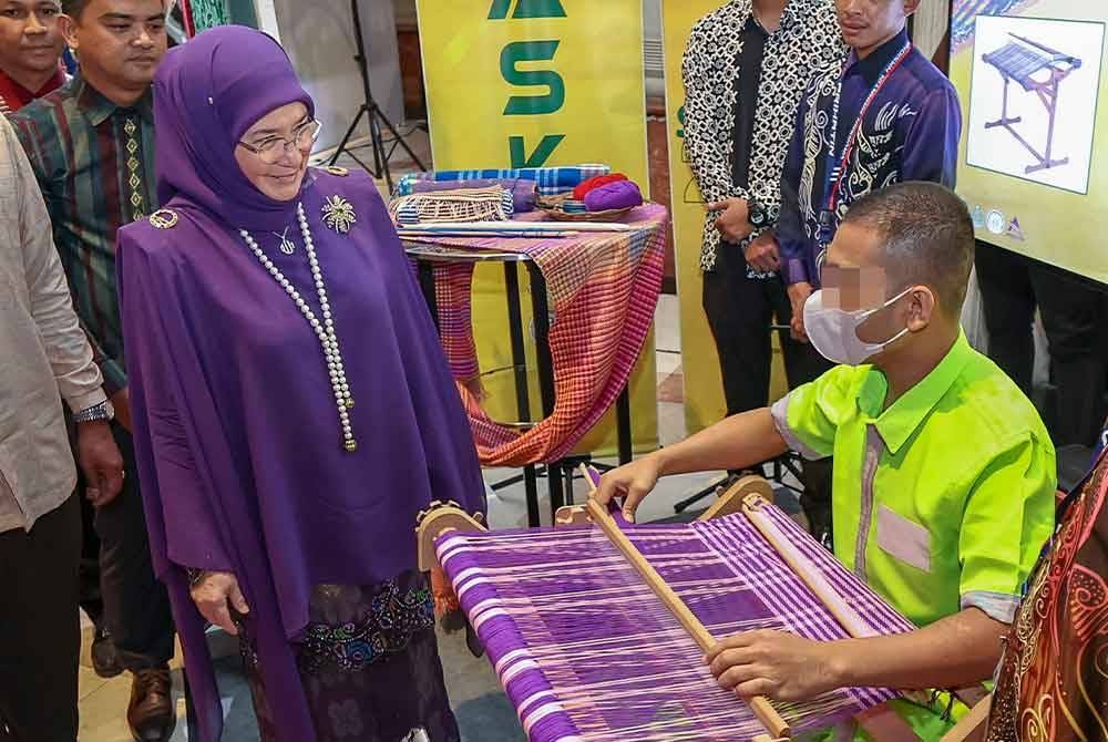 Tunku Azizah berkenan melihat penghuni penjara menenun songket semasa majlis Malam Simfoni Kasih 2023 Jabatan Penjara Malaysia di Putrajaya.