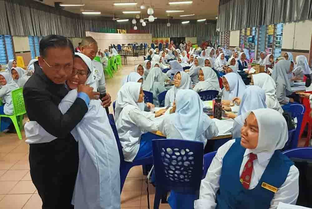 Azman memeluk anaknya, Farah Amirah Aqilah sebelum peperiksaan SPM berlangsung di STF, Johor Bahru pada Selasa.