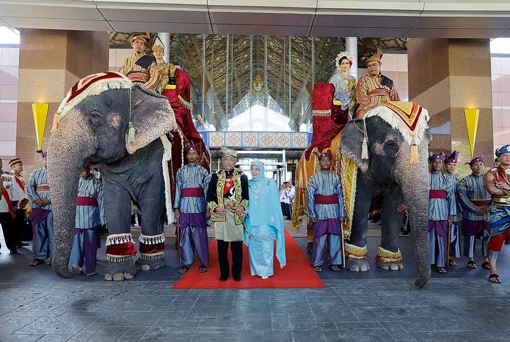 Yang di-Pertuan Agong Al-Sultan Abdullah Ri'ayatuddin Al-Mustafa Billah Shah dan Raja Permaisuri Agong Tunku Azizah Aminah Maimunah Iskandariah berkenan bergambar bersama dua ekor gajah Myan Thon Pian dan Rambai yang mengepalai perarakan menyambut ketibaan Seri Paduka di Kompleks Bunga Raya, Lapangan Terbang Antarabangsa Kuala Lumpur (KLIA) hari ini. Foto Bernama