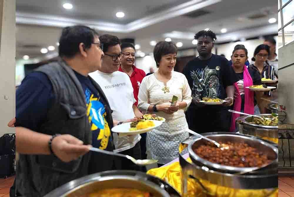 Nicole Tan (tengah) melihat menu yang disediakan kepada ejen pelancongan dari Asia Barat