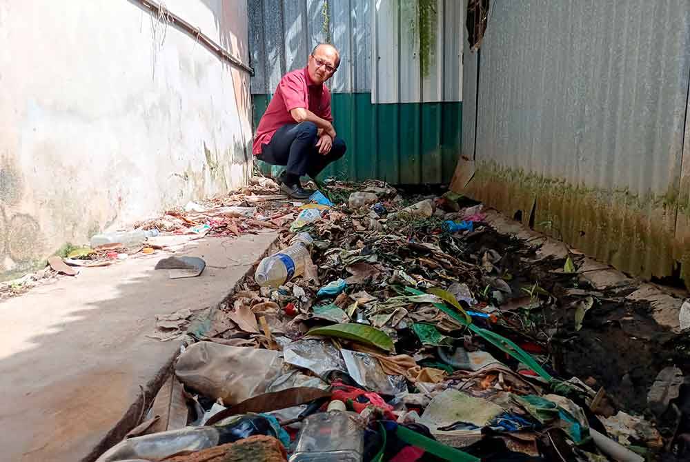 Hee Sem memeriksa persekitaran asrama pekerja warga asing yang kotor dan dipenuhi sampah sarap. Foto Bernama