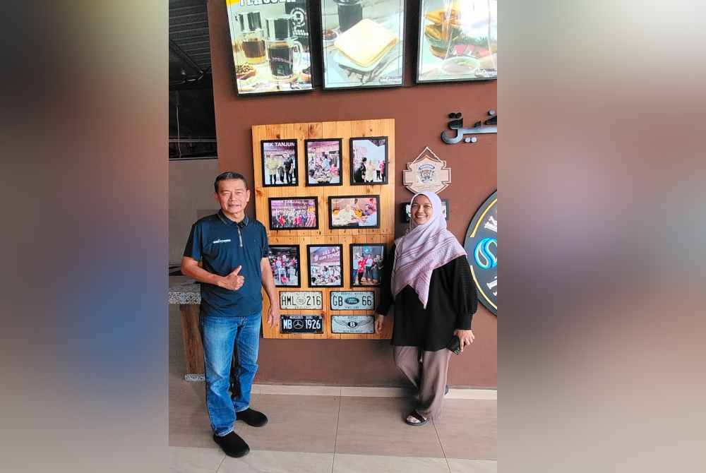 Ghazali (kiri) menunjukkan sudut galeri gambar kenangan bersama Sultan Ibrahim di Kafe Kopi Tenggek Tanjung Piai.