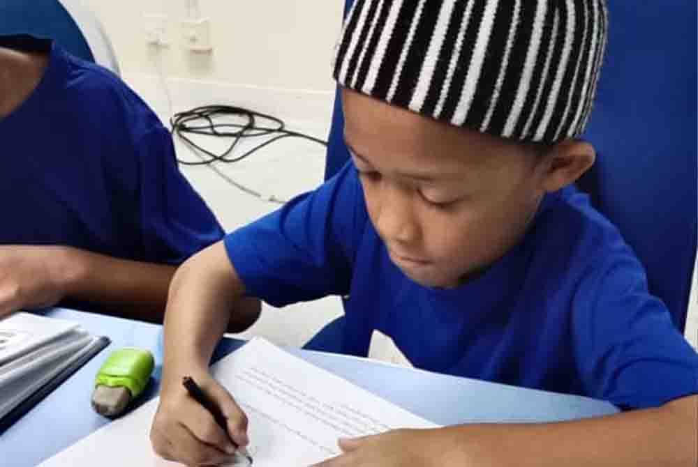 Seorang kanak-kanak melukis kartun dan menghasilkan komik berkaitan pengajaran surah.